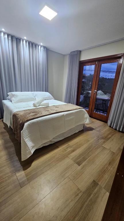 a bedroom with a large bed and a large window at Casa Violeta in Ouro Preto