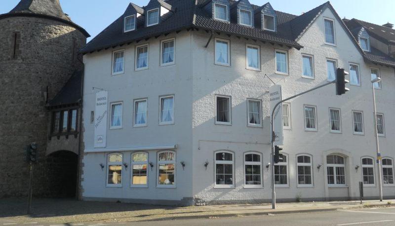 a large white building on the corner of a street at Hotel am Hexenturm in Jülich