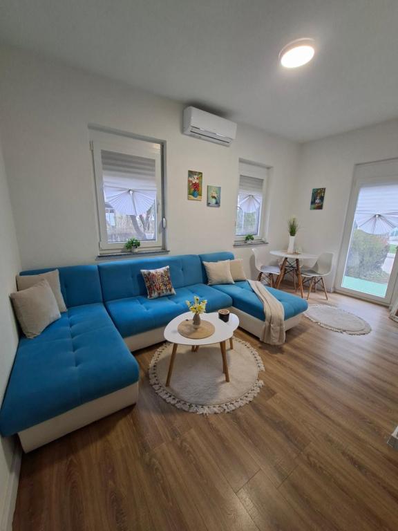 a living room with a blue couch and a table at Apartman Hana in Bihać