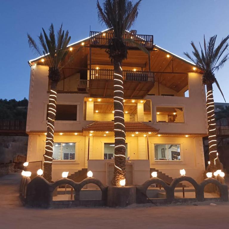 a building with palm trees in front of it at الشريف in Irbid