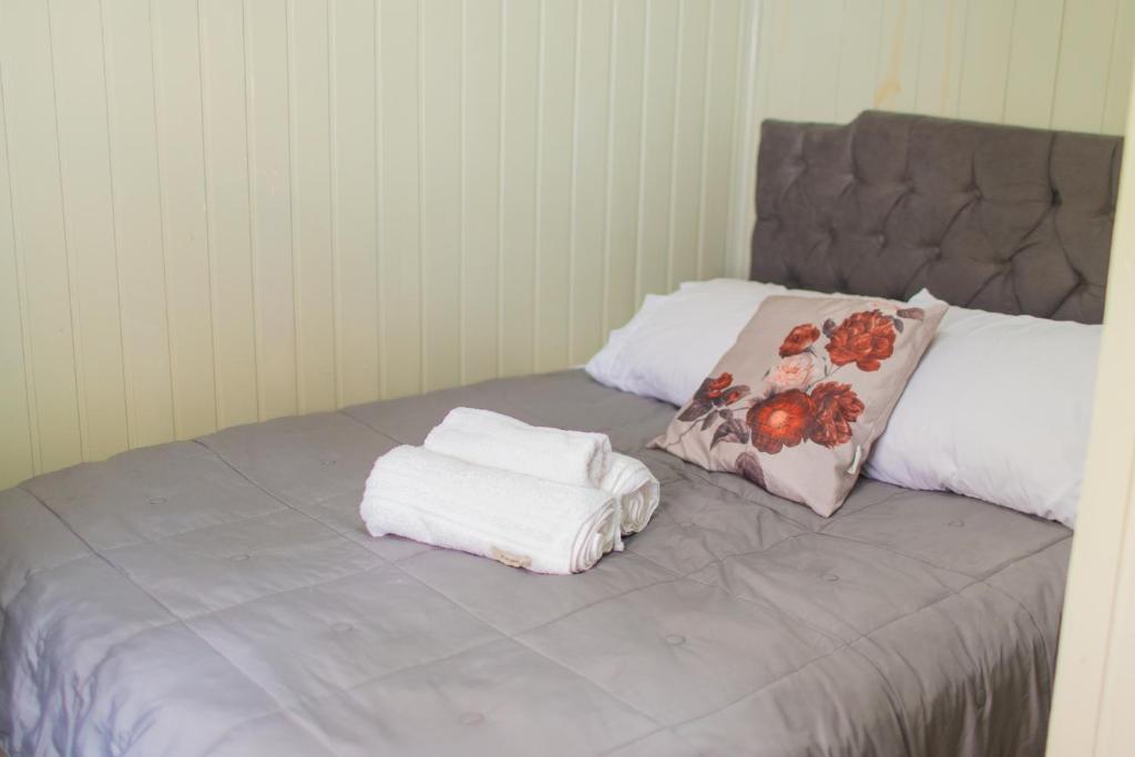 a bed with two towels sitting on top of it at Chalé 10 min do centro in Gramado