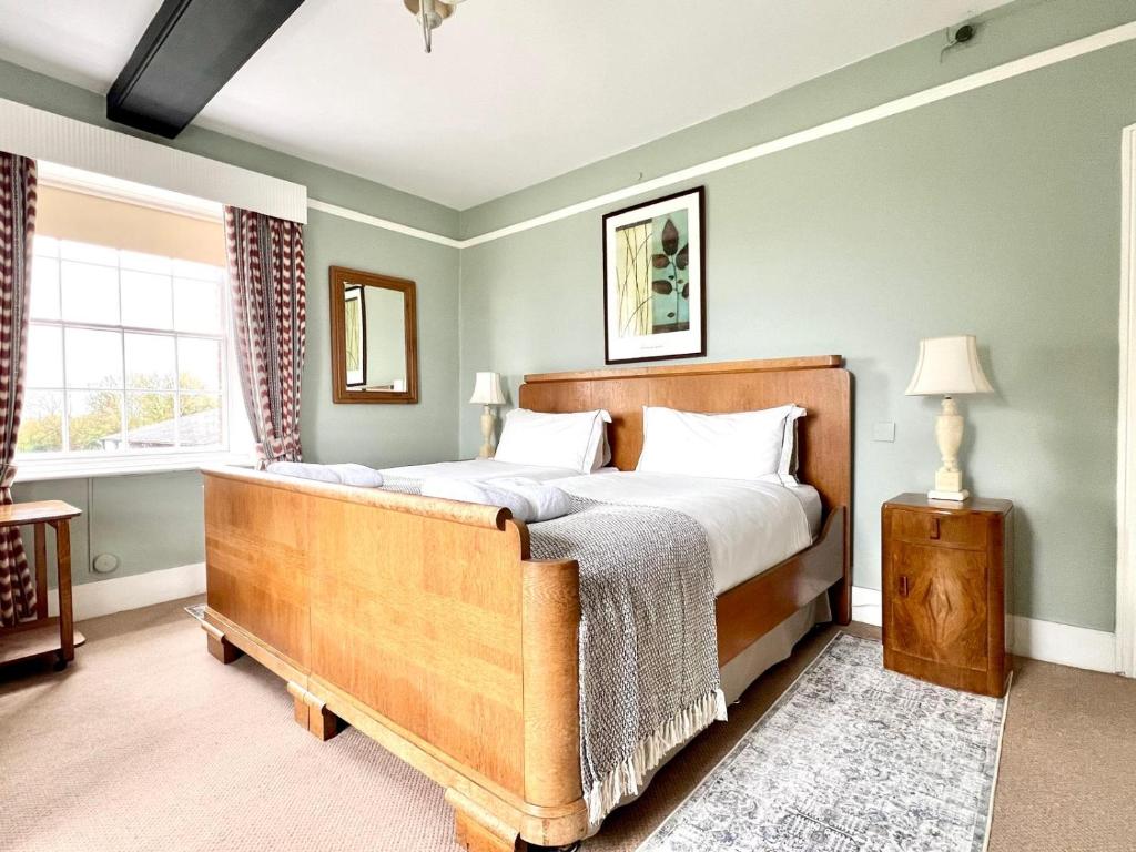 a bedroom with a large bed and a window at Colthrop Manor B&B in Thatcham