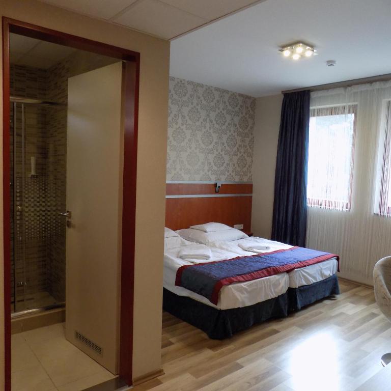Postel nebo postele na pokoji v ubytování Fortuna Hotel