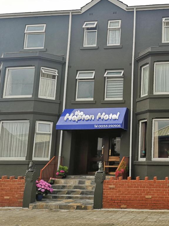 a black building with a blue awning on it at The Hopton Hotel in Blackpool