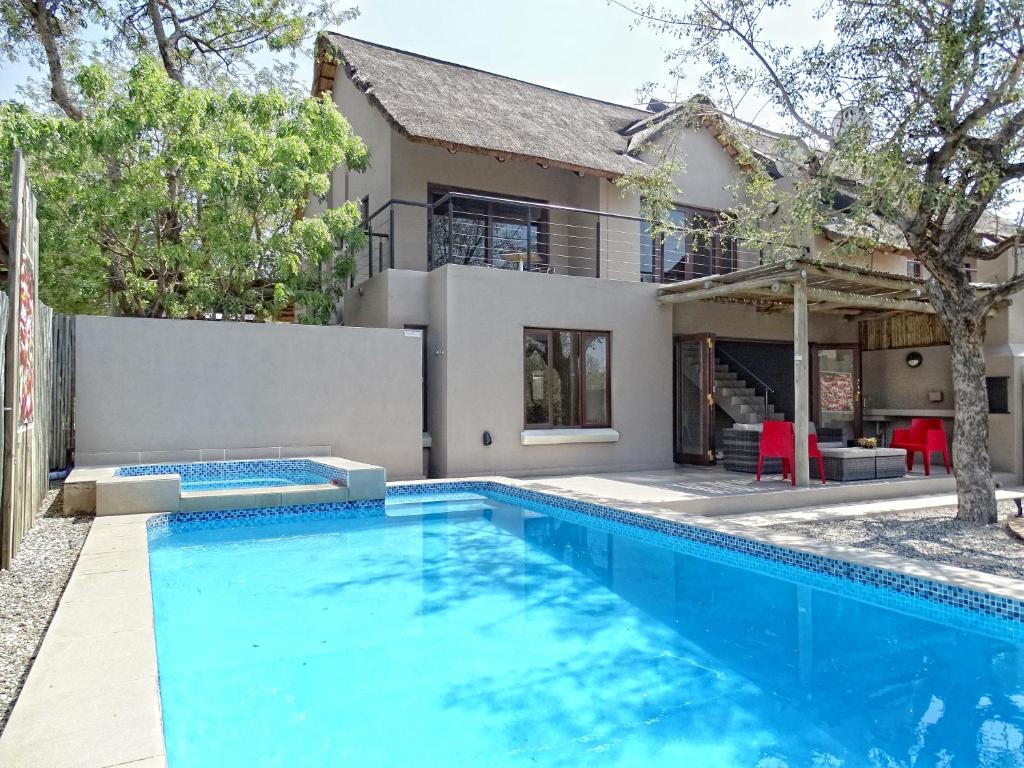 a swimming pool in front of a house at BushGlam Luxury Holiday Home in Hoedspruit