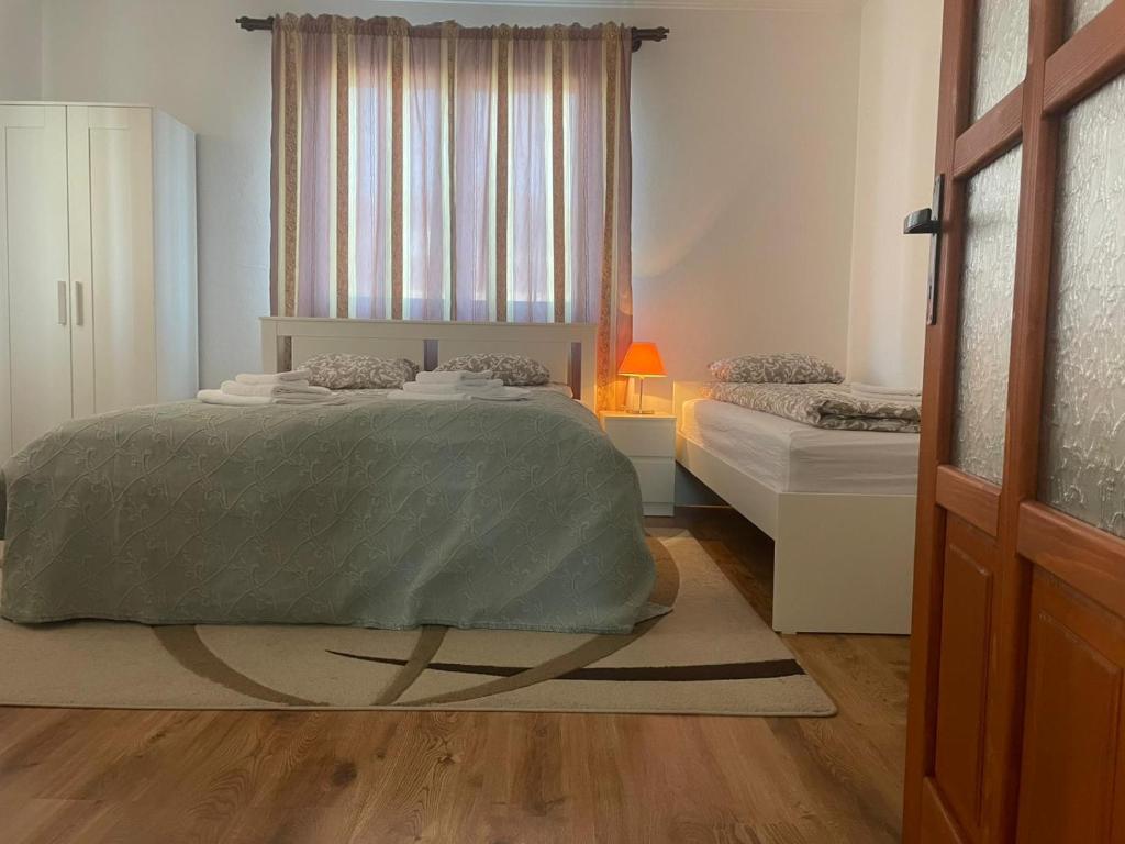 a white bedroom with a bed and a window at Csilla Vendégház Remete in Remetea