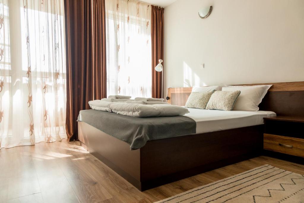 a bedroom with a bed with white sheets and a window at Студио 3 Слънчево Утро in Hisarya