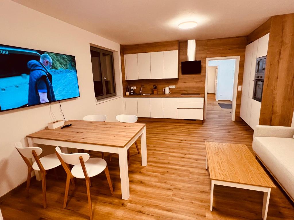 a kitchen and living room with a table and chairs at PORTA Apartment in Františkovy Lázně