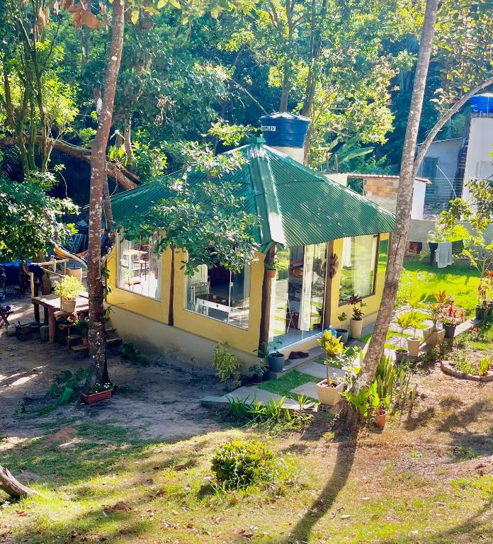 a yellow house with a green roof and trees at Reserva da Reserva Praia do Forte in Mata de Sao Joao