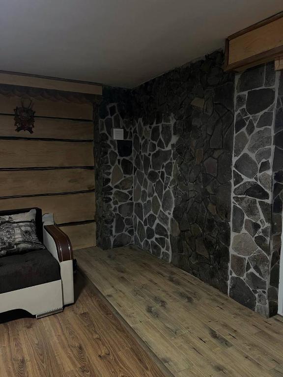 a room with a stone wall and a bed at Pryhirska Sadyba in Torunʼ