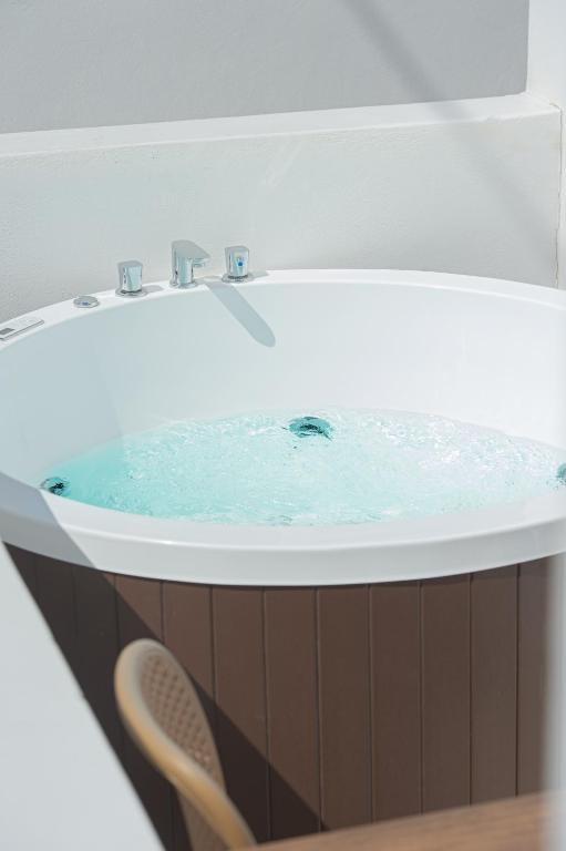 a bath tub with blue water in it at Santo Evdokia in Vóthon