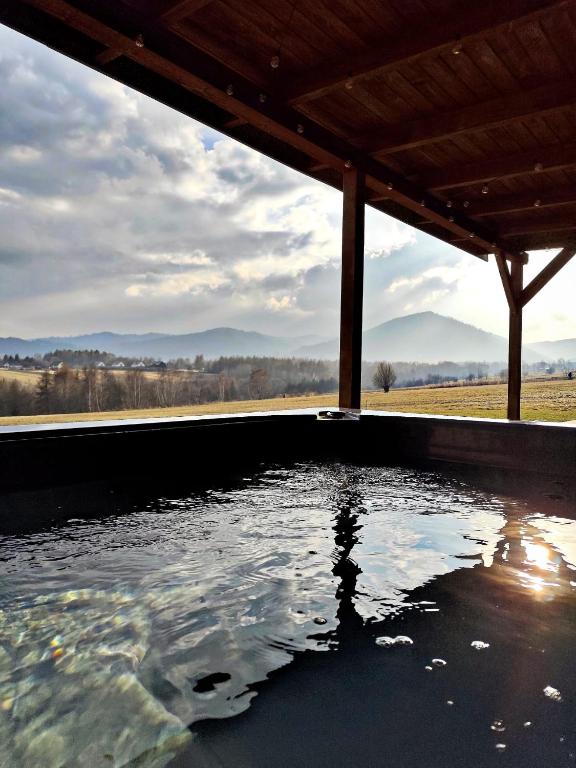 a pool of water sitting under a roof at Górska Stodoła - Domek z Prywatnym Jacuzzi in Lipowa