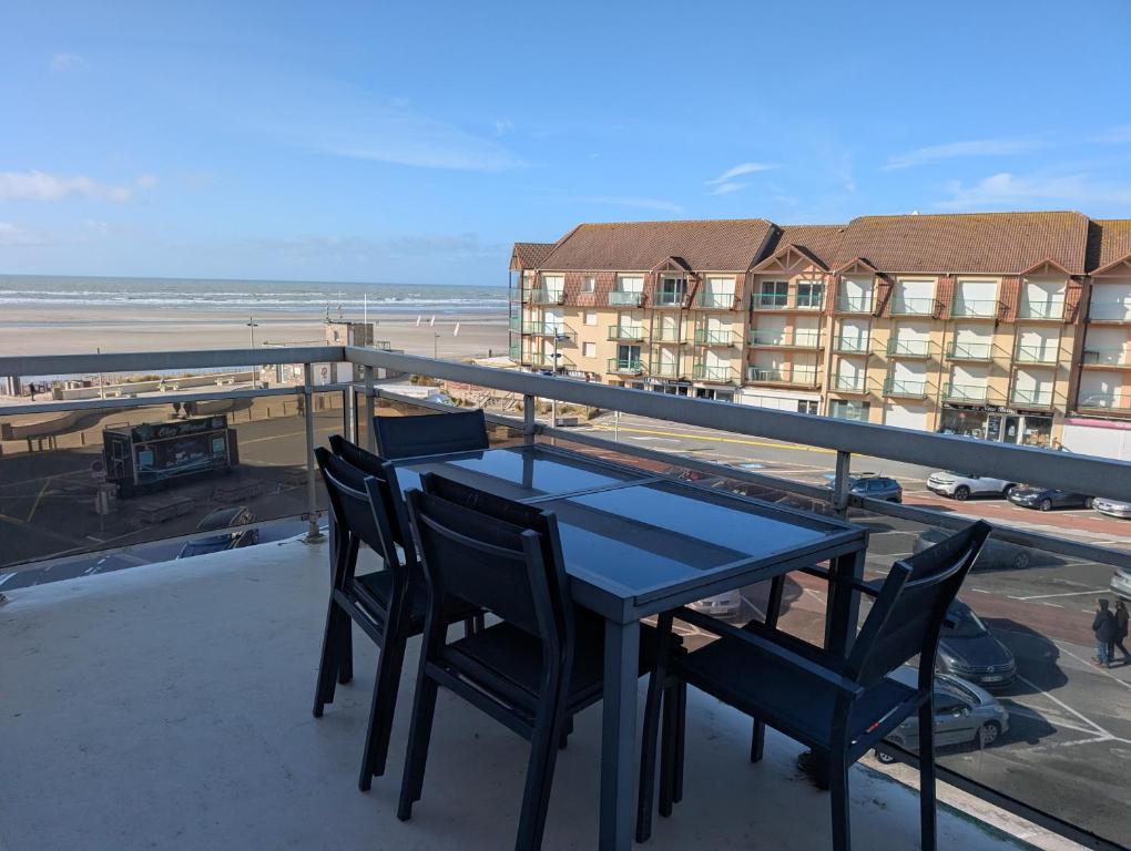 a table and chairs on a balcony with a view of the beach at La vague in Camiers