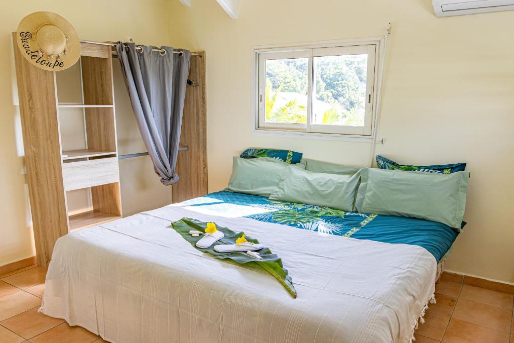 a bedroom with a large bed with a window at Kaz KOKOYE in Baie-Mahault