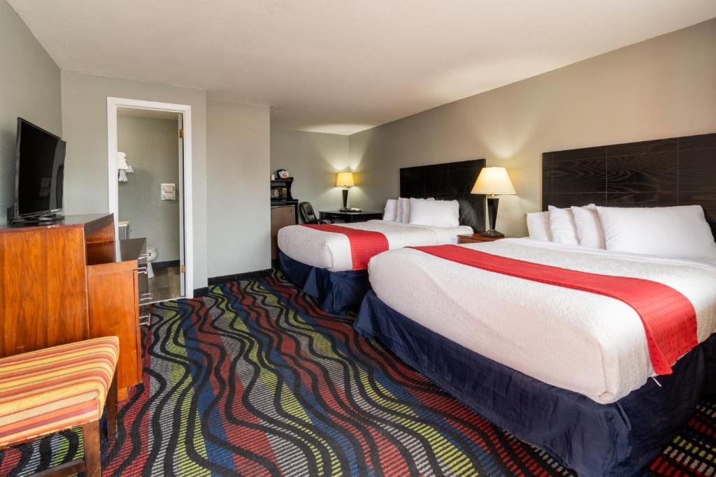 a hotel room with two beds and a flat screen tv at Sunset Motel and RV in Alliance
