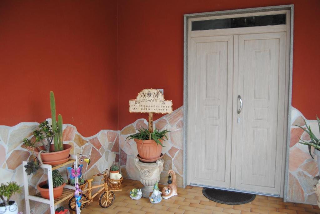 a room with potted plants and a white door at A&M House in Vignanello
