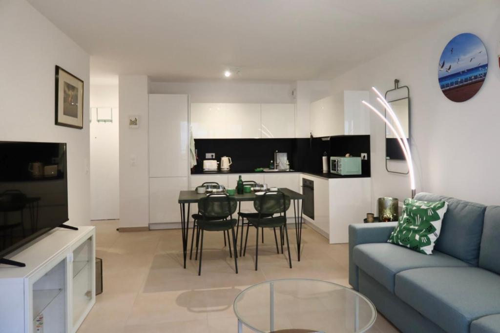 a living room with a blue couch and a table at Nice Time - Chic Apartment with sunny terrace, Nice Port in Nice