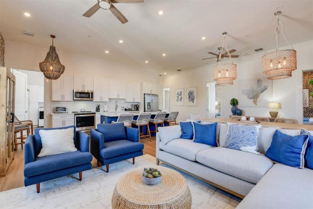 a living room with blue furniture and a kitchen at Harbor House Penthouse- B in Key West