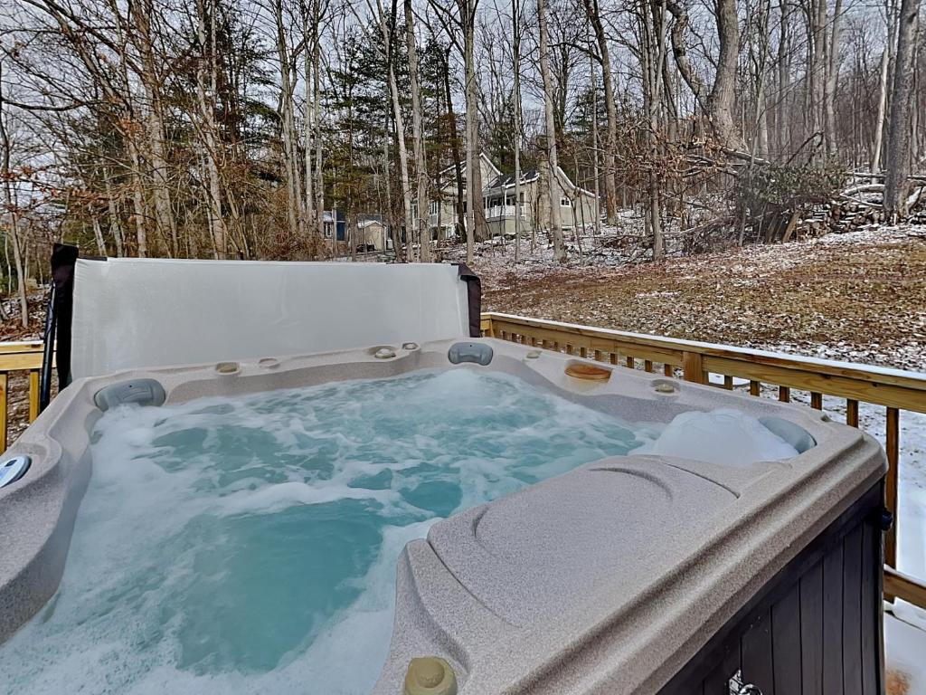a jacuzzi tub on a deck in the snow at Fawn View Cabin in McHenry