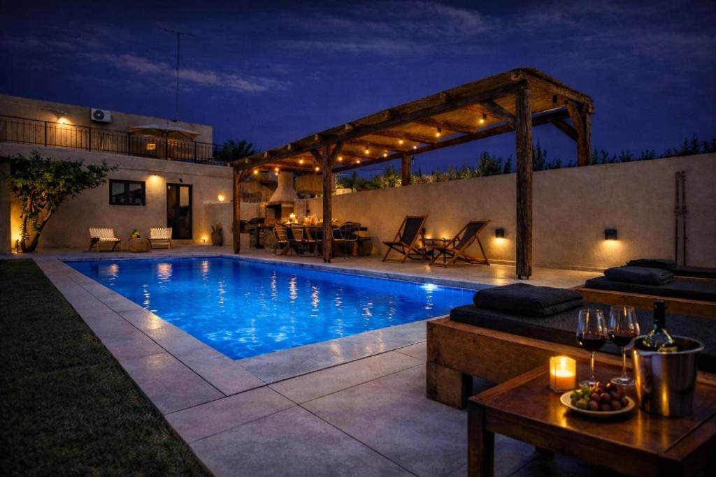 a swimming pool in a backyard at night at stone villa marianna With private pool &guest studio in Moukhtároi