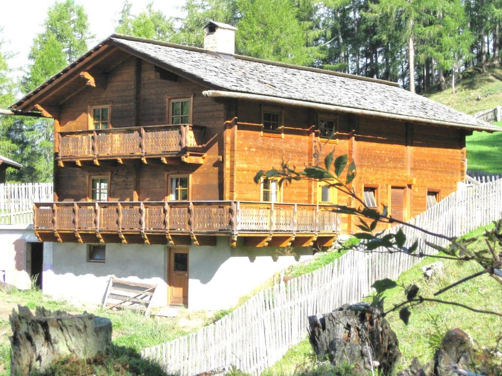 a large wooden house with a balcony on it at Almhütte Adlerhorst in Heiligenblut