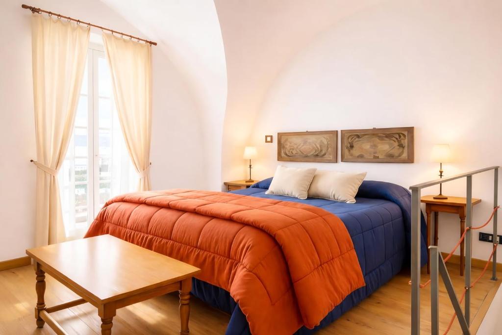 a bedroom with a bed with an orange blanket at Damiani Case Vacanze Palermo - Centro Storico in Palermo