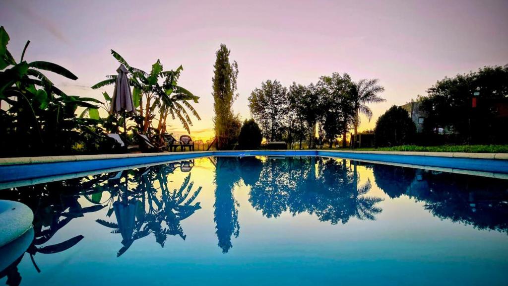 a swimming pool with the reflection of the sky in the water at Cabaña La Joaquina in Colón