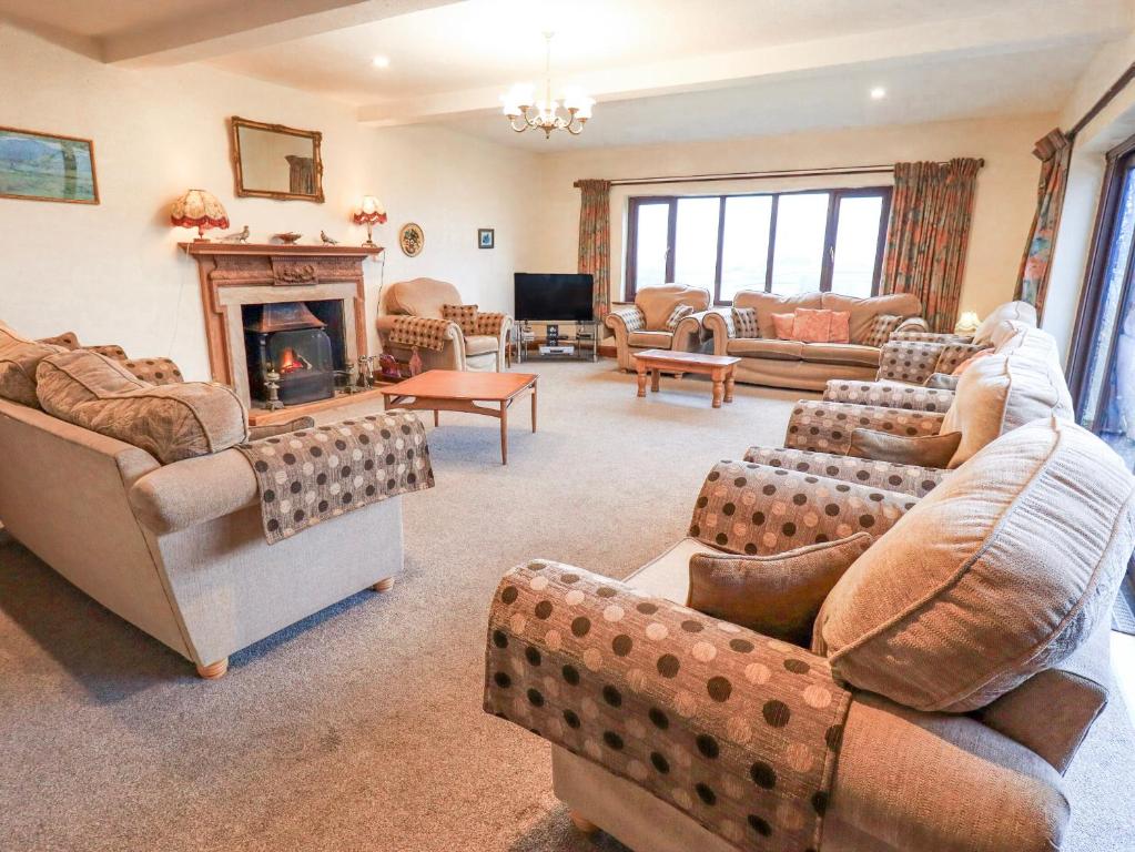 a large living room with couches and a fireplace at Ghyll Bank House in Staveley
