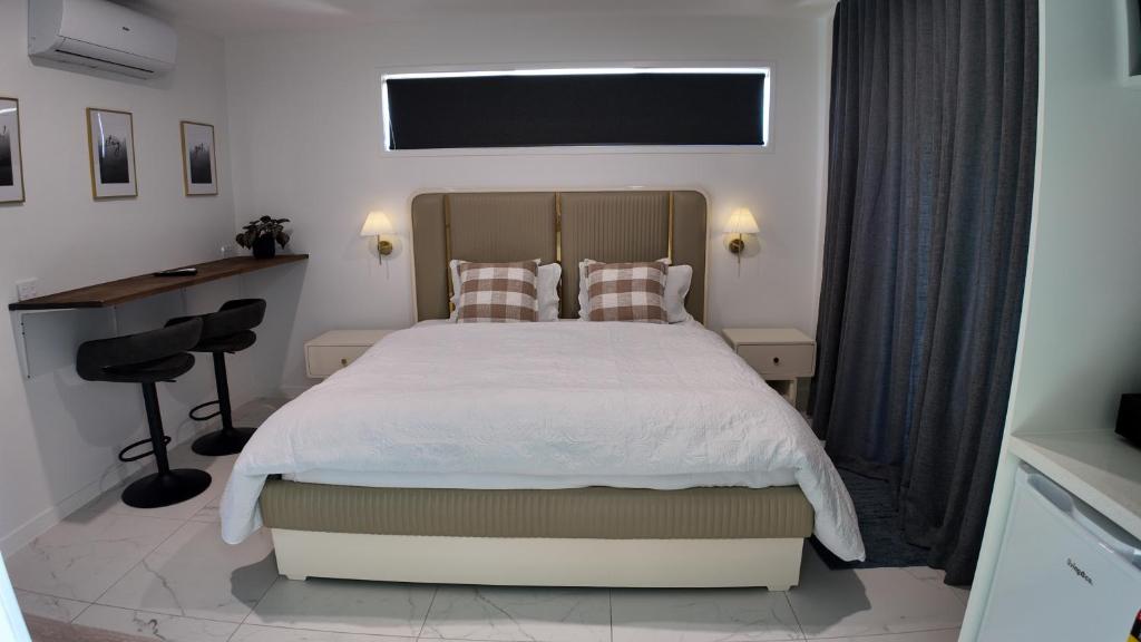 a bedroom with a large bed and a desk at Taupo Premium Retreat - Private Spa & Ensuite in Taupo