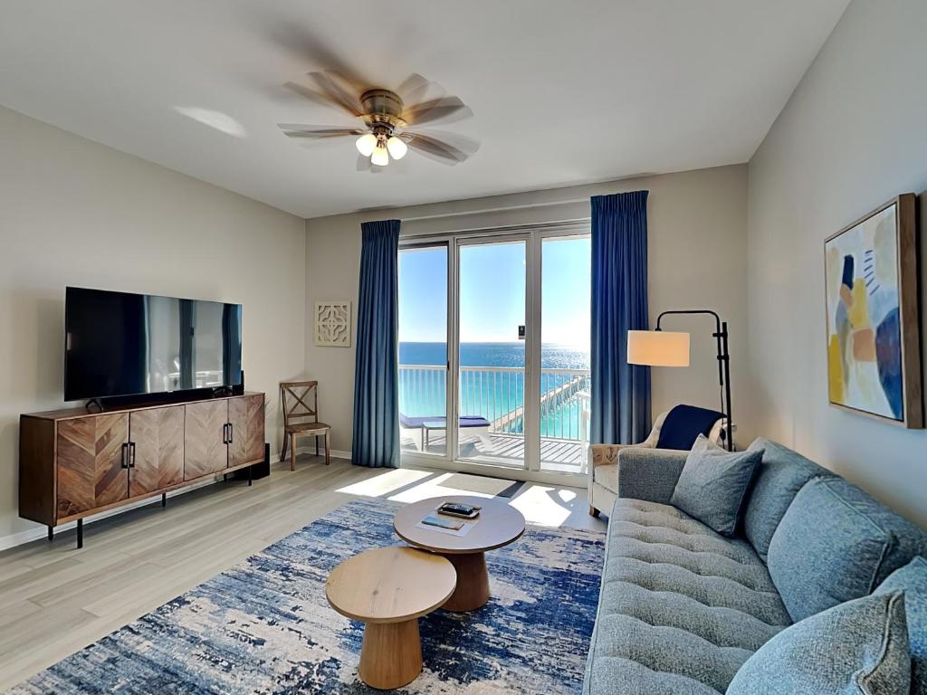 a living room with a blue couch and a tv at Inn at Summerwinds #1403 in Navarre