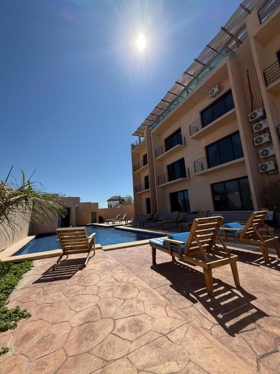 two chairs and a swimming pool in front of a building at STELLA MARIS Boutique Hotel in El Sargento