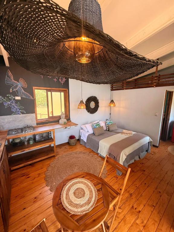 a bedroom with a bed and a large ceiling at Tiny House Al lado del río in Linares