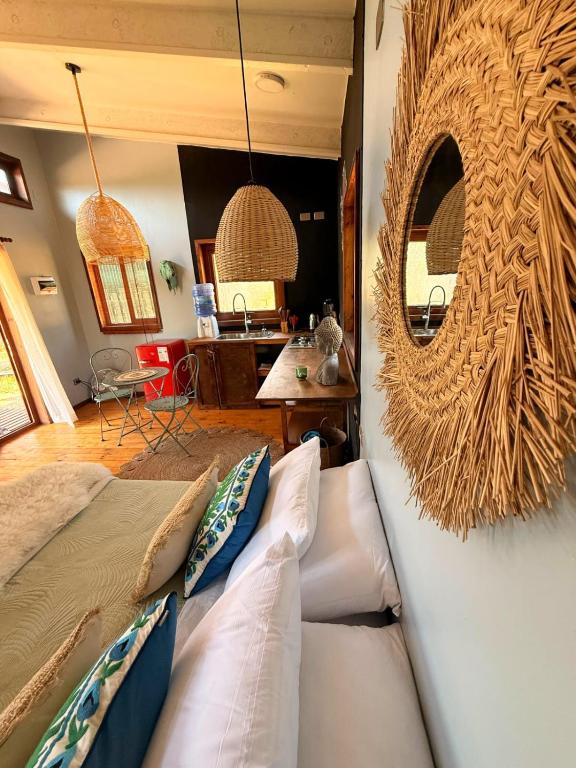 a living room with a couch and a mirror at Tiny House Detrás del río in Colbún
