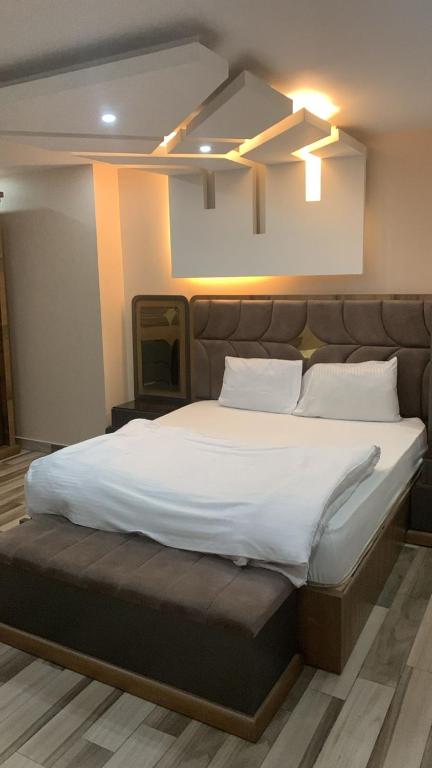 a bedroom with a large bed with white sheets and pillows at Zm apartment shehab Vib in Giza