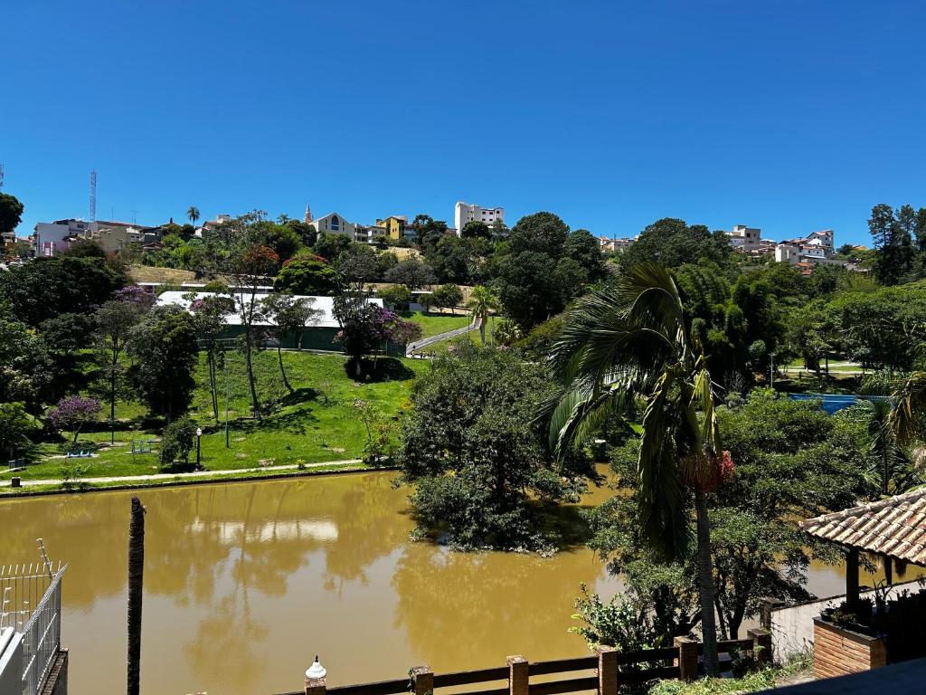 a pool of muddy water in a park with trees at Pousada Acordes do Lago in Cunha