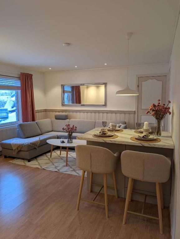 a kitchen and living room with a couch and a table at Leilighet in Bjørkheim