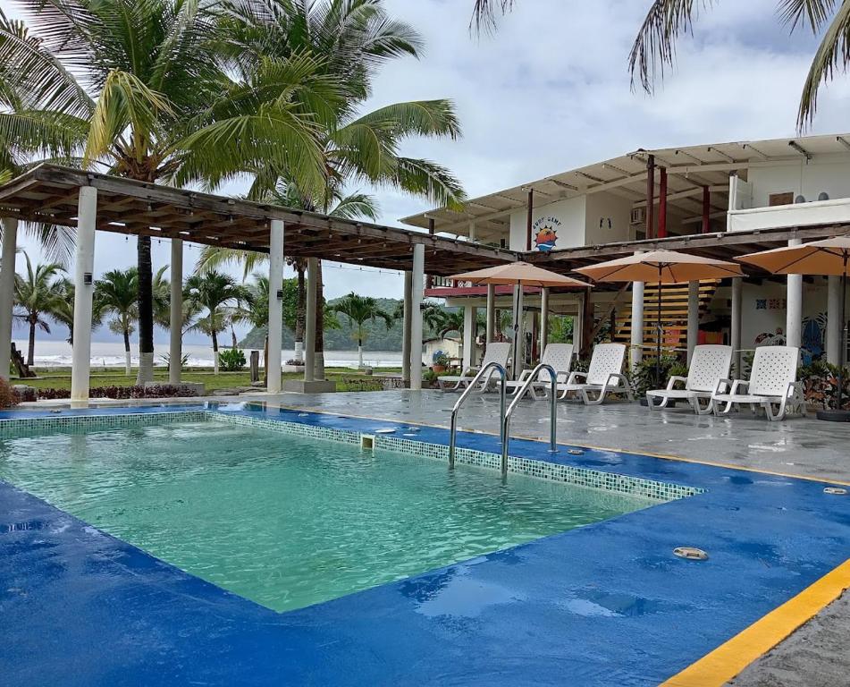 a pool at a resort with chairs and umbrellas at Guanico Beach Resort in Tonosí