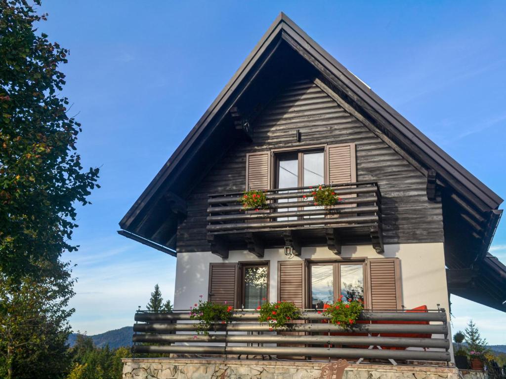 a house with windows and flowers on the steps at Chalet Makov Hrib by Interhome in Tršće