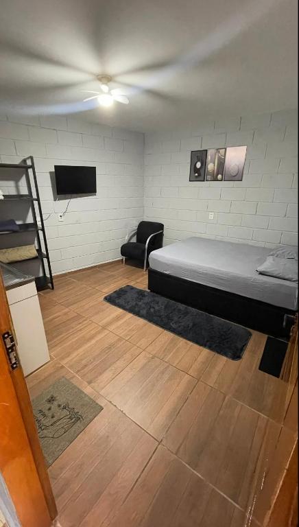 a room with a bed and a couch and a television at Quarto Para Dormir Próximo do Aeroporto Gru POUSO RÁPIDO in Guarulhos