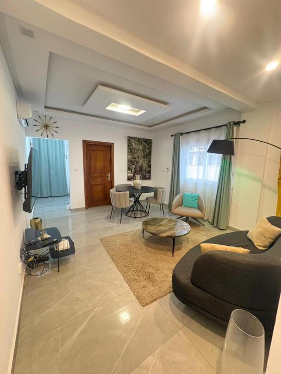 a living room with a bed and a dining room at Les Sublimes Residences Tweens in Abidjan