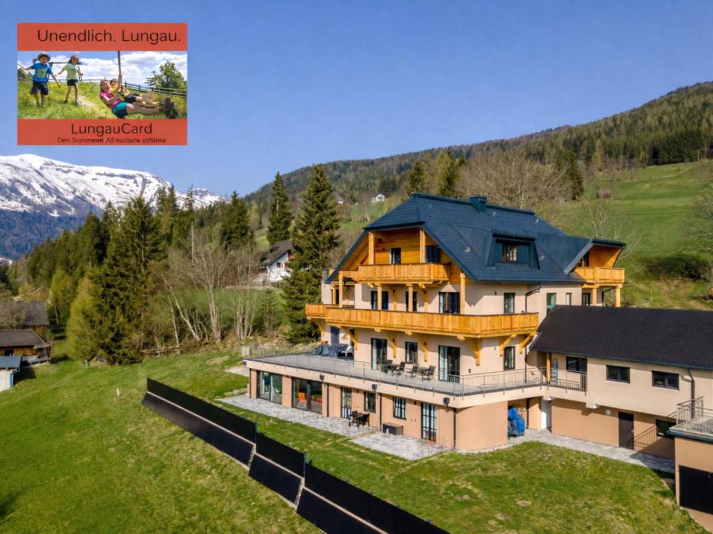 a large house with a blue roof on a green field at Lärchenhof Top 01 in Mauterndorf