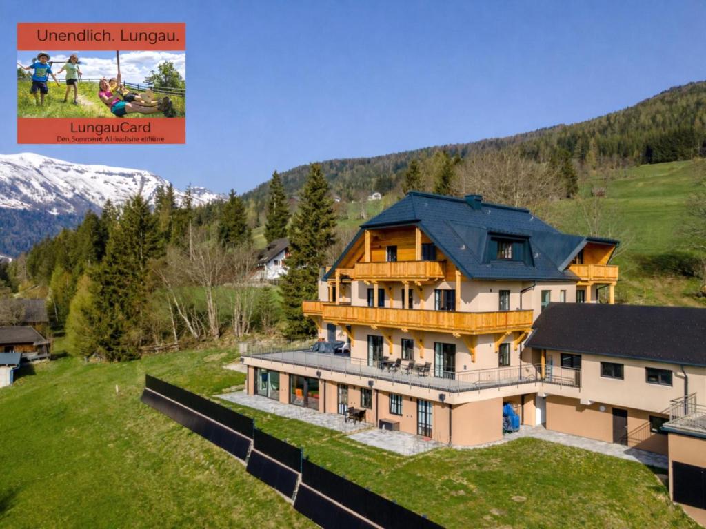 a large house with a blue roof on a green field at Lärchenhof Top 101 in Mauterndorf