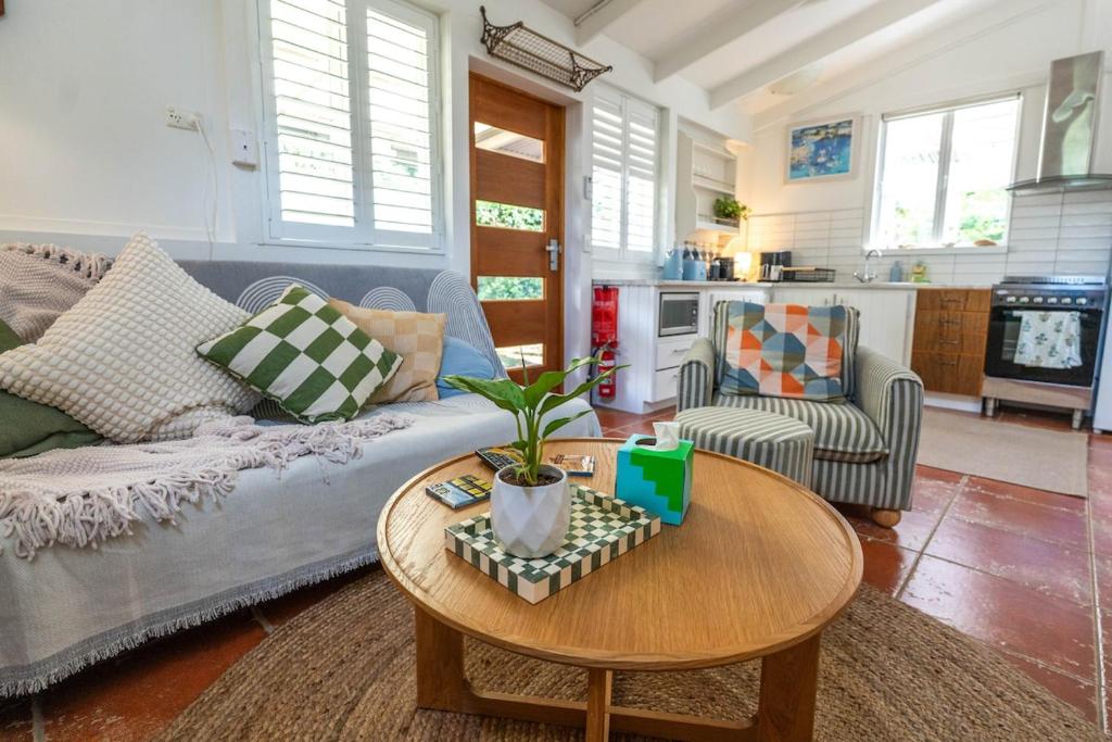 a living room with a couch and a table at The Lotus Cottage Maleny in Witta