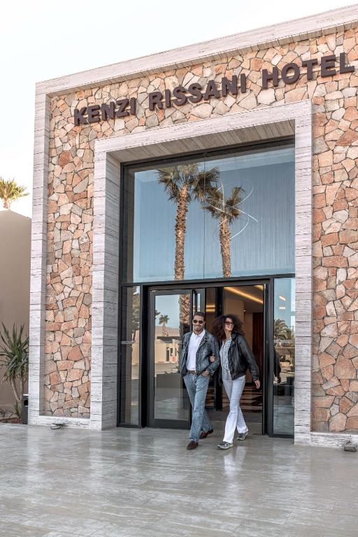 a man and a woman standing outside of a building at Kenzi Rissani in Er Rachidia