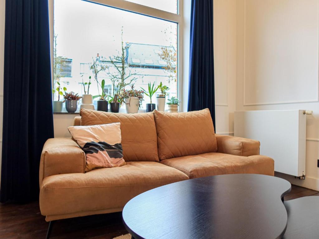 a living room with a couch and a table at Cosy Courtyard House Hasselt in Hasselt