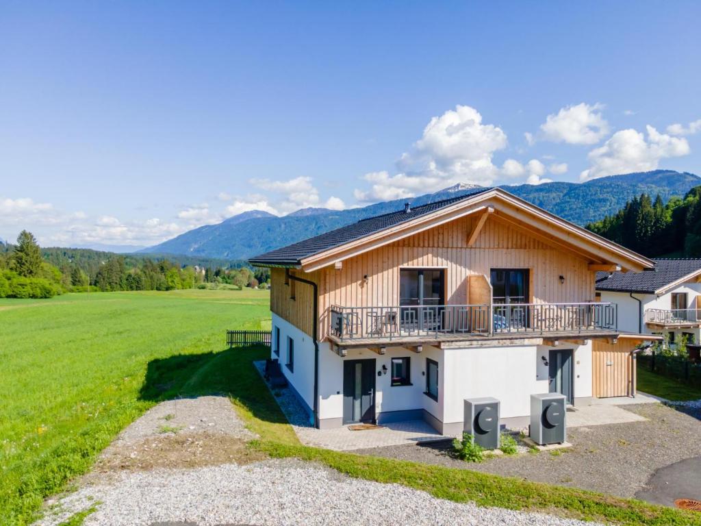 a house with a balcony and mountains in the background at Sauna Chalet 9B in Obermöschach