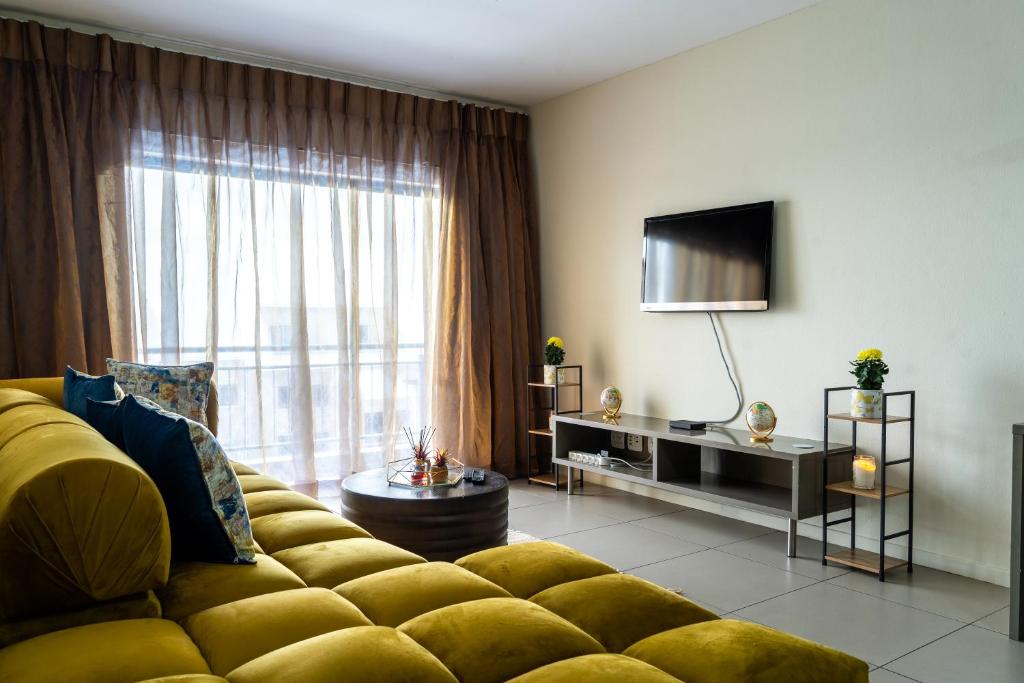 a living room with a yellow couch and a television at Ngalufuno-wlove in Johannesburg