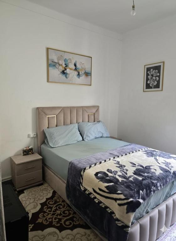 a bedroom with a bed with a blanket and a night stand at Appartement 3S in Meknès