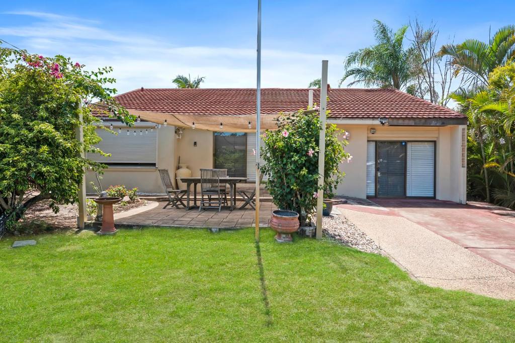 a house with a garden with a patio at Casa Bella in Bongaree