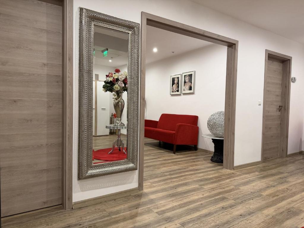 a mirror in a living room with a red chair at Hotel Zur Post in Haren